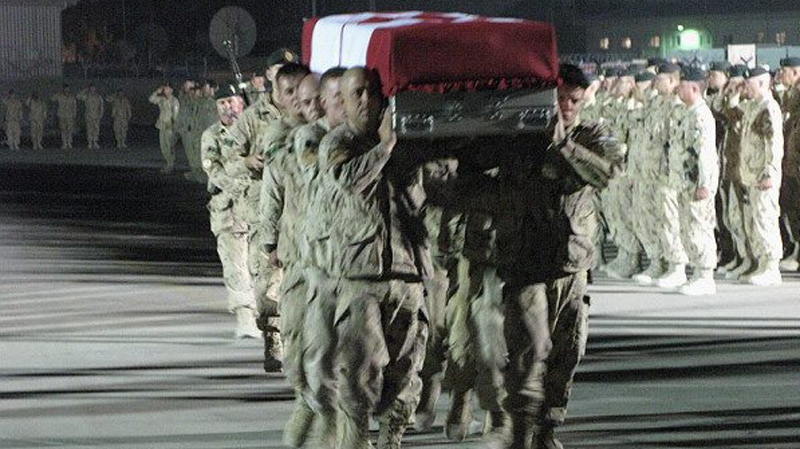Soldiers carry the casket of Sapper Brian Collier during a ramp ceremony at Kandahar Airfield in Afghanistan on Wednesday July 21, 2010. (Bill Graveland / THE CANADIAN PRESS)