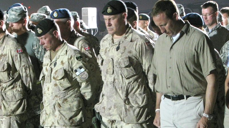 Brig. Gen. Jonathan Vance, second front left, Canada's Chief of Defence Staff, Gen. Walter Natynczyk, second right and Defence Minister Peter MacKay, right, pay tribute at a ramp ceremony for Sapper Brian Collier at Kandahar Airfield, in Afghanistan on Wednesday July 21, 2010. (Bill Graveland / THE CANADIAN PRESS)