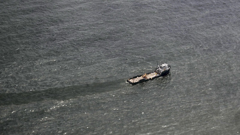 A boat cuts through a sheen of oil near the Deepwater Horizon oil spill site in the Gulf of Mexico, off the Louisiana coast, Tuesday, July 20, 2010. (AP Photo/Gerald Herbert)