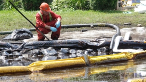 In this July 29, 2010 file photo, a worker monitors water in Talmadge Creek in Marshall Township, Mich., near the Kalamazoo River as oil from a ruptured pipeline, owned by Enbridge Inc., is attempted to be trapped by booms. (AP / Paul Sancya)