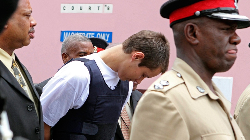 Colton Harris-Moore, the teenage fugitive police have dubbed the 'Barefoot Bandit,' is escorted handcuffed by Bahamian authorities to the court building in Nassau, Tuesday July 13, 2010. (AP / Tim Aylen)