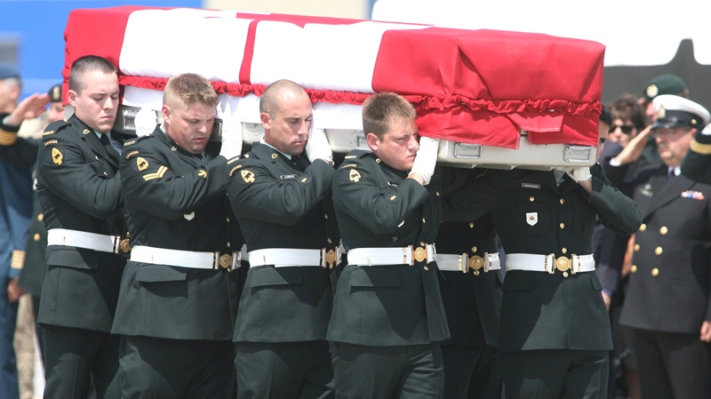 The casket containing the remains of Sapper Brian Collier is carried past grieving family members and friends during a repatriation ceremony at CFB Trenton on Friday July 23 2010. (Peter Redman / THE CANADIAN PRESS)