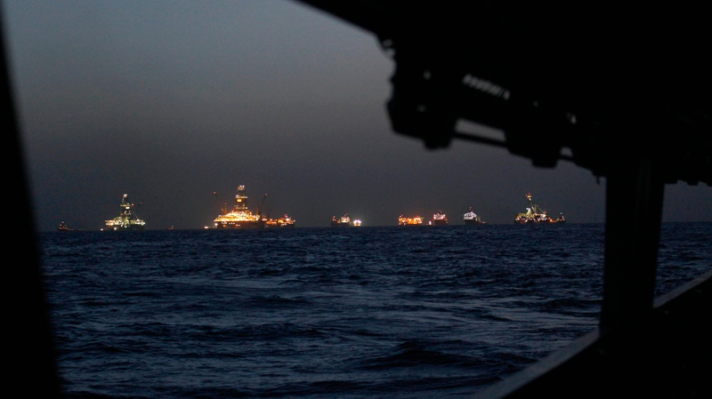 Vessels are seen at dusk from the deck of the Coast Guard Cutter Decisive at the Deepwater Horizon oil spill site in the Gulf of Mexico, off the Louisiana coast, Thursday, July 22, 2010. (AP / Gerald Herbert)