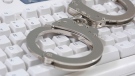Handcuffs on a computer keyboard can be seen in this file photo.