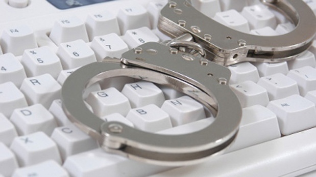 Handcuffs on a computer keyboard can be seen in this file photo.