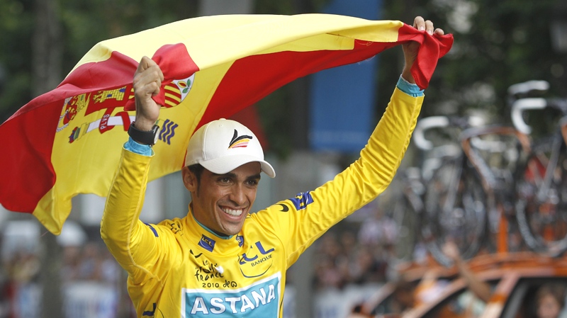 Three-time Tour de France winner Alberto Contador  of Spain holds aloft the Spanish national flag during a victory lap with his Astana teammates after the 20th and last stage of the Tour de France cycling race over 102.5 kilometers (63.7 miles) with start in Longjumeau and finish in Paris, France, Sunday, July 25, 2010. (AP / Christophe Ena)