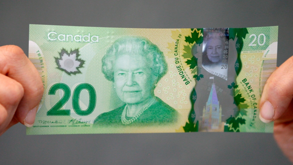 A Bank of Canada employee holds the new $20 bill at the bank in Ottawa