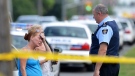 Civilians speak to the Police on Tuesday July 17, 2012 near the scene of a shooting on Danzig Street where 19 people were injured and 2 confirmed dead at an outdoor barbecue that took place on Monday July 16, 2012 . (Aaron Vincent Elkaim / THE CANADIAN PRESS)