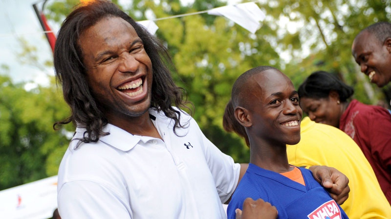 NHL player Georges Laraque jokes around with a Haitian boy outside Grace Children's Hospital in Port-au-Prince, Haiti, Tuesday, June 8, 2010. The NHL Players' Association donating more than $1 million to help rebuild a hospital in Haiti. (NHLPA / THE CANADIAN PRESS)