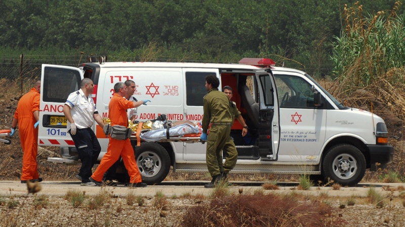 Israeli soldiers and medics carry an Israeli soldier, injured during an exchange of fire with Lebanese troops, out of an ambulance to a helipad to be transported to hospital, near the northern Israeli town of Kiryat Shmona, Tuesday, Aug. 3, 2010. (AP / Hamad Almakt)