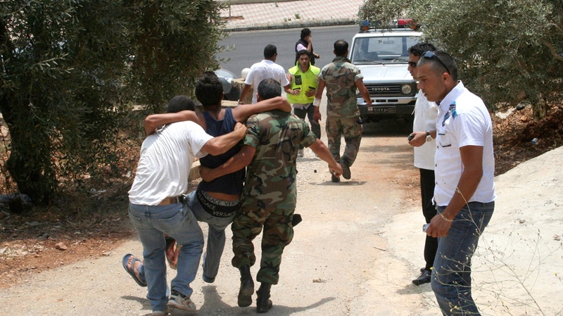People carry an injured man after an exchange of fire between Israeli and Lebanese troops along the border between Israel and Lebanon, in the southern border village of Adaisseh, Lebanon, Tuesday, Aug. 3, 2010. (AP / Ronith Daher)