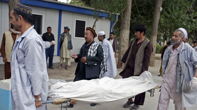 Hospital staff move bodies of some of six Kabul Bank security guards who were beheaded during a bank robbery in Mazar-e-Sharif, north of Kabul, Afghanistan, Tuesday, Aug. 3, 2010. (AP Photo/Mustafa Najafizada)