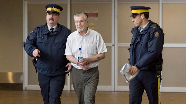 Ernest Fenwick MacIntosh is escorted in custody by RCMP officers at Robert L. Stanfield International Airport in Halifax on Thursday, June 7, 2007. (Andrew Vaughan / THE CANADIAN PRESS)