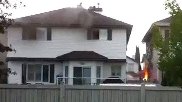 In an still taken from CTV News footage, a flare from a gas line can be seen between two homes in the Glastonbury neighbourhood in southwest Edmonton on Monday, July 23.