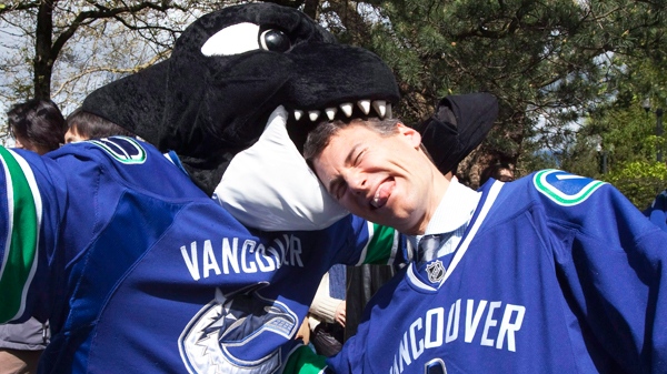 Fin, the Vancouver Canucks mascot, left, bites Vancouver Mayor Gregor Robertson on the head after the mayor declared Tuesday, April 27, 2010 Canucks Day following the teams advancement to the second round of the NHL playoffs. Vancouver Mayor Gregor Robertson's loose lips didn't sink a ship, but they have left him neck deep in controversy. Robertson forgot the microphone was on at a city council meeting last week and, in a clip that's been uploaded to YouTube, cursed and criticized a group of public speakers. (Jonathan Hayward / THE CANADIAN PRESS)
