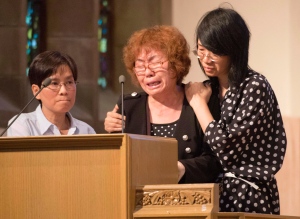 The mother of Lin Jun, Zhi Gui Du cries uncontrollably as she is comforted by a friend (right) as she speaks about her son during a public memorial for Lin in Montreal Saturday, July 21, 2012. A translator looks (left) on. (Peter McCabe / THE CANADIAN PRESS)