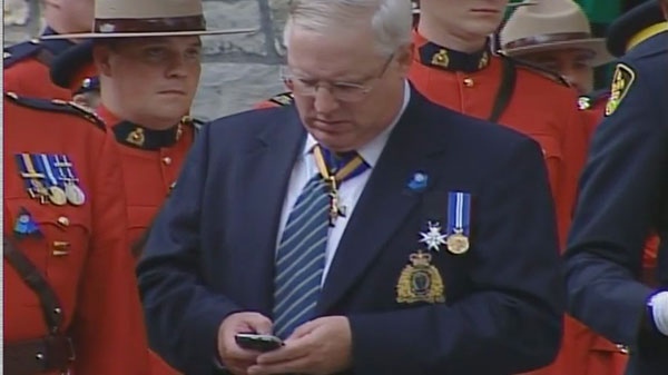 RCMP Commissioner William Elliott uses his BlackBerry at the funeral of Const. Michael Potvin, Aug. 4, 2010.