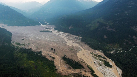 Smoke from wildfires hangs in the air as mud and debris fills a valley along the Lillooet River after a landslide occurred near Meager Creek Hot Springs north of Pemberton, B.C., on Friday August 6, 2010. (CP/Darryl Dyck) 