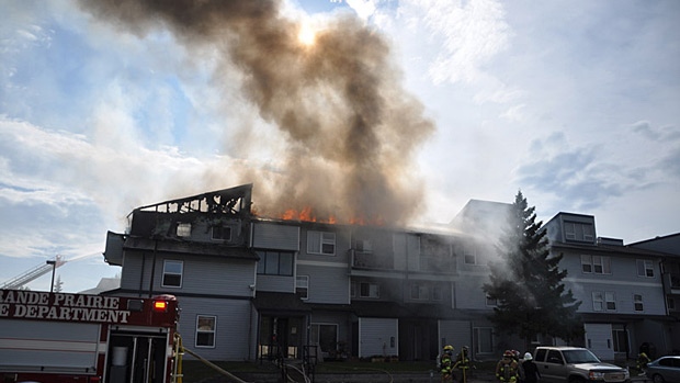 Officials say a barbecue was the cause of a fire that tore through a Grande Prairie condominium and forced residents out of their homes on Friday. Photo: William Vavrek.