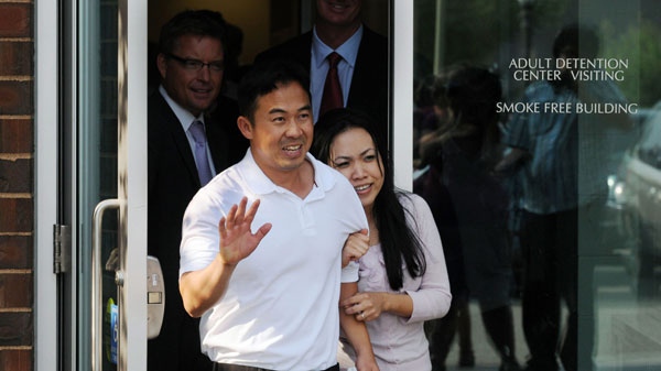 Koua Fong Lee, left, waves to a gathered crowd outside the Ramsey County Adult Detention Center in St. Paul, MN, as he leaves with his wife, Panghoua Moua, after hearing that charges against him were dropped, on Thursday, Aug. 5, 2010. (AP /Pioneer Press, Ben Garvin) 