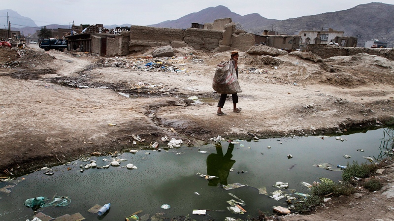 An Afghan boy walks for collecting empty bottles in Kabul, Afghanistan on Tuesday, Aug 10, 2010. (AP / Musadeq Sadeq)