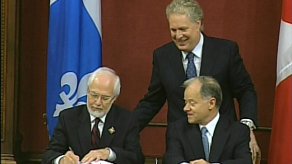 Lieutenant Governor Pierre Duchesne signs the book confirming Raymond Bachand's new role as Finance and Revenue Minister, as Premier Jean Charest looks on. (August 11, 2010)