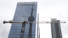 The CN Tower is reflected in a high rise building behind a construction crane in downtown Toronto on Saturday, Feb. 4, 2012. (Pawel Dwulit / THE CANADIAN PRESS)