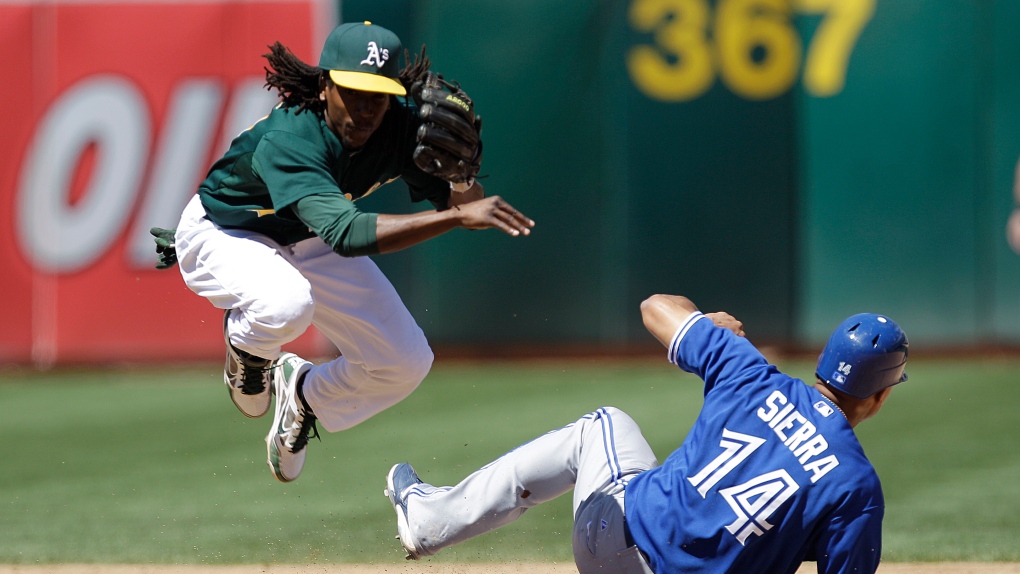 Toronto Blue Jays' Moises Sierra (14) breaks up a double play as Oakland Athletics second baseman Je
