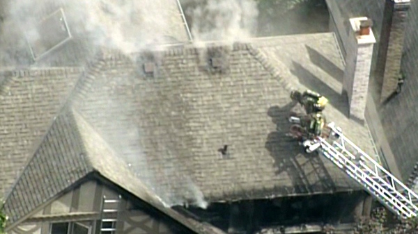 Firefighters battle the blaze at Kurt Browning's Forest Hill mansion in Toronto, Tuesday, Aug. 18, 2010.