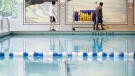 A person sweeps the deck at a pool in Toronto. (The Canadian Press/Michelle Siu)