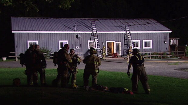 Firefighters stand at scene of fire that erupted at wedding chapel in North Gower, Ont. Aug. 13, 2012