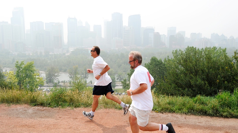 Smoke from B.C. forest fires blankets the downtown as joggers John Dimaulo, left, and Mark Carter brave poor air quality in Calgary, Alta. on Friday, Aug. 20, 2010. (Larry MacDougal / THE CANADIAN PRESS)