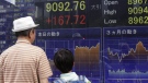 A man and a child look at a securities firm's electronic stock board in Tokyo Thursday, Aug. 16, 2012.  (AP Photo/Shizuo Kambayashi)