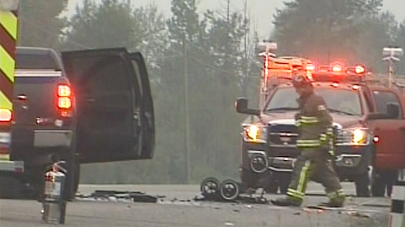 Fire officials at the scene of a crash that killed the parents of a newborn baby on Highway 8 near Cochrane, Alta. on Saturday, Aug. 21, 2010.