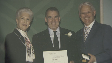Former VPD officer Dave Dickson, center, accepts an award from B.C. Premier Gordon Campbell. 