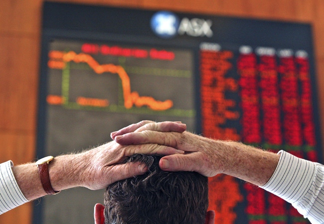 A lunch time visitor to the Australian Securities Exchange watches a board showing stock prices and a graph of the day's trade in Sydney, Australia on Wednesday, Jan. 16, 2008. (AP / John Pryke)