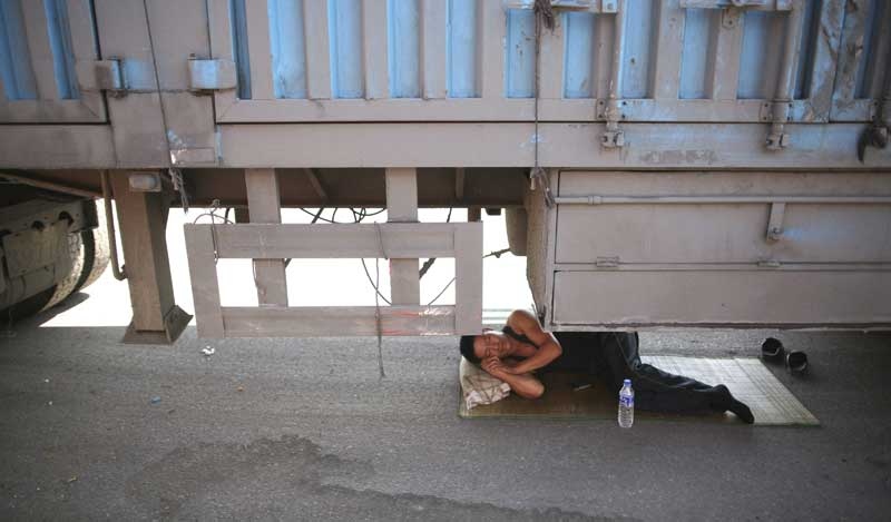 In this photo taken Monday, Aug. 23, 2010, a driver takes a nap under his truck jammed on an entrance ramp to the Beijing-Tibet Highway in Guoleizhuang township, in north China's Hebei province. The massive traffic jam that stretches for dozens of miles hit its 10-day mark on Tuesday.(AP Photo)