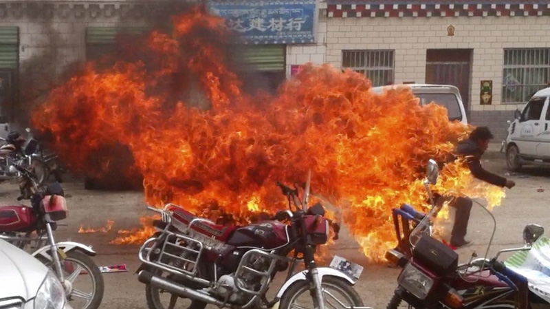 A Tibetan runs in flames on a street in Yushu, Qinghai, China on June 20, 2012.