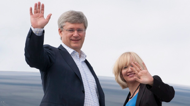 Prime Minister Stephen Harper and his wife Laureen wave as they depart on a northern tour of Canada at the airport in Ottawa on Monday, Aug. 20, 2012. (The Canadian Press/Adrian Wyld)