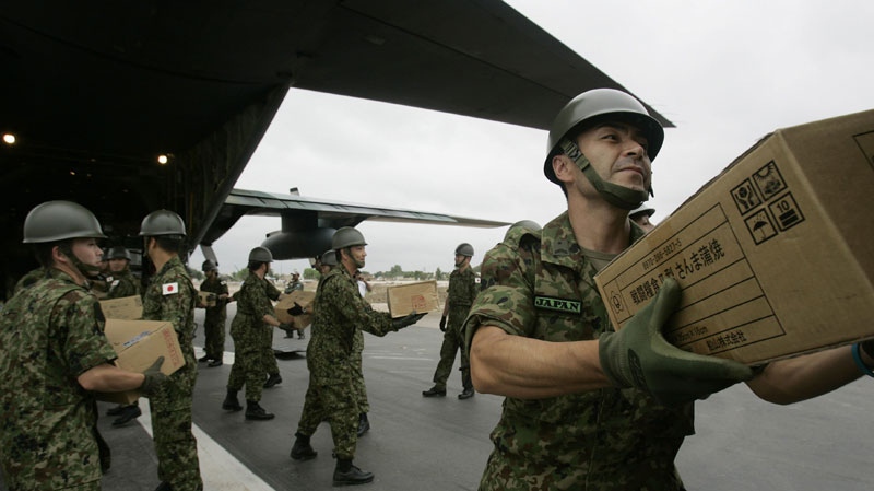 A Japanese soldier unloads boxes from their C130 military plane as they arrive at the airport in Multan, Pakistan on Wednesday Aug. 25, 2010. (AP Photo/Aaron Favila)