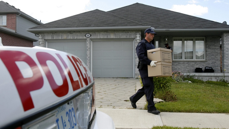 RCMP investigators remove evidence boxes from a home in London, Ont., Thursday, Aug. 26, 2010. (Dave Chidley / THE CANADIAN PRESS)