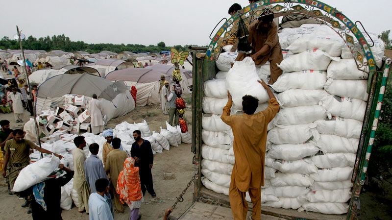 Workers unload relief goods from a truck at an army relief camp for displaced people at Sultan Colony in Muzaffargarh district, Punjab province, Pakistan on Wednesday Aug. 25, 2010. (AP / Aaron Favila)