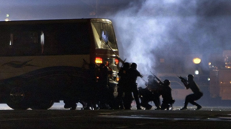 Members of the SWAT teams prepare to assault the tourist bus seized by dismissed police officer Rolando Mendoza Monday, Aug. 23, 2010 at Manila's Rizal Park, Philippines. (AP Photo/Pat Roque)