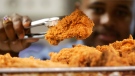  In this Monday, Oct. 30, 2006 file photo, a Kentucky Fried Chicken employee uses tongs to hold up an sample of the company's trans fat-free Extra Crispy fried chicken in New York. (AP / Kathy Willens, File)