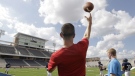 Football coach Jeff Fleener tosses a football to players during practice at the new $60 million football stadium at Allen High School Tuesday, Aug. 28, 2012 in Allen, Texas. (AP Photo/LM Otero)