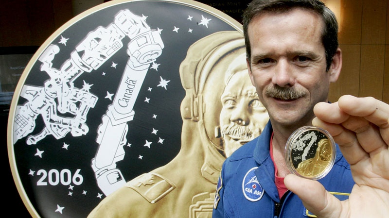 Canadian astronaut Colonel Chris Hadfield shows off a newly minted coin with his likeness commemorating the fifth anniversary of his, and Canada's, first space walk by a Canadian at the Royal Canadian Mint in Ottawa, Wednesday, May 31, 2006. (Hanson / THE CANADIAN PRESS)