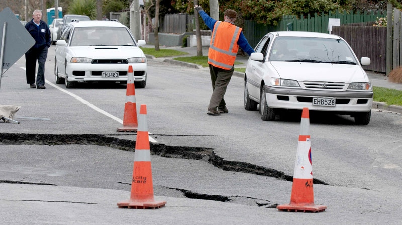 Motorists stop their cars near cracks caused in the road around the Avon River in Avonside, Christchurch, New Zealand, Sunday, Sept. 5, 2010. (AP / NZPA, David Alexander)