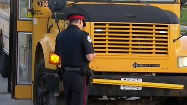 A Toronto police officer writes up a school bus for allegedly speeding in a school zone on Tuesday, Sept. 7, 2010.