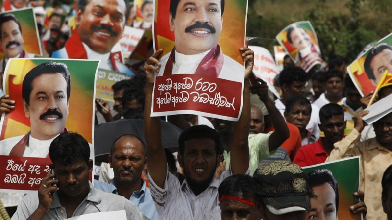 Sri Lankan government supporters carry portraits of President Mahinda Rajapaksha as they rally around the parliament complex in Colombo, Sri Lanka, Wednesday, Sept. 8, 2010. (AP Photo/Eranga Jayawardena)