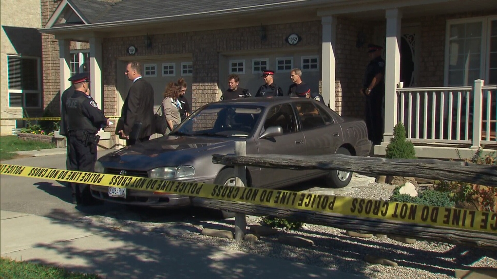 Police officials are shown at a house where two bodies were discovered in Milton